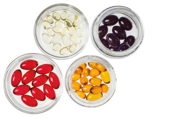 Multicolored transparent capsules with vitamins or medicine in glass iars isolated