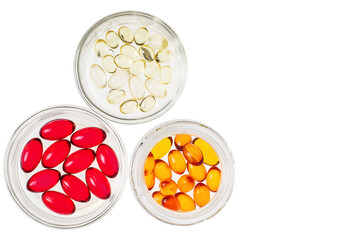 Multicolored transparent capsules with vitamins or medicine in glass iars isolated
