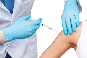 Doctor gives a syringe with vaccine to patient at clinic.