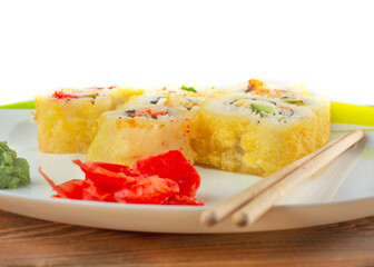 close-up of sushi on a white plate with wasabi and ginger and wooden chopsticks