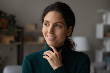 Happy pensive millennial Hispanic woman look in distance dreaming or visualizing achievement or perspectives. Smiling young Latino female make plan or imagine, think of career success opportunities.