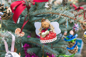 Handmade natural walnut Christmas decoration on Christmas tree. Christmas Angel with wings, star and violin cello. DIY ideas for children. Environment, reuse, upcycling concept. Selective focus