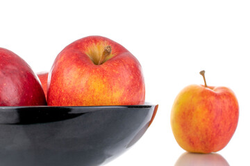 Three juicy red apples on a ceramic plate, close-up, isolated on white.