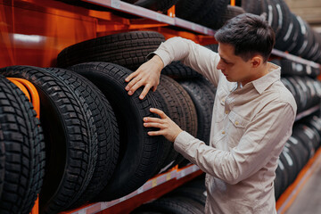 Fototapeta na wymiar male customer choosing new tires in the supermarket .