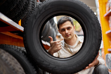 Obraz na płótnie Canvas male customer taking new tires in the supermarket.