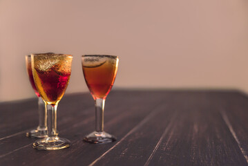 Alcoholic drinks in glass piles on a wooden table. Cherry, nut and lemon liqueurs.