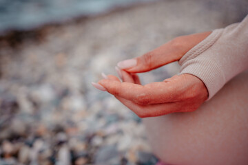 Young woman with black hair, fitness instructor in leggings and tops doing stretching and pilates on yoga mat near the sea. Female fitness yoga routine concept Healthy lifestyle harmony and meditation