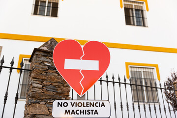 Traffic sign in the shape of a broken heart pleading for the end of gender violence that reads 