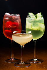 three cocktails in a dark bar