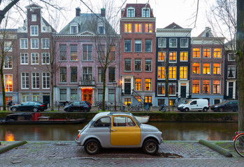 Fototapeta na wymiar Beautiful old houses on the city waterfront of Amsterdam at sunset.
