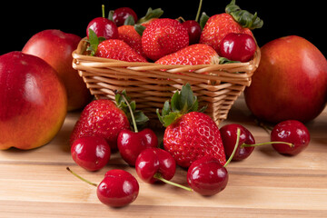 Bamboo board with tasty strawberries, cherries and nectarines.
