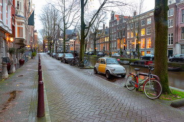 Beautiful old houses on the city waterfront of Amsterdam at sunset.