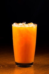 orange cocktail with ice on a dark background