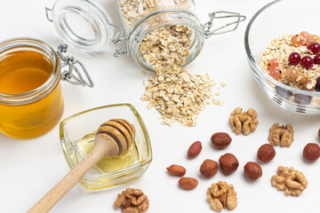 Honey stick in a bowl. Nuts on table.