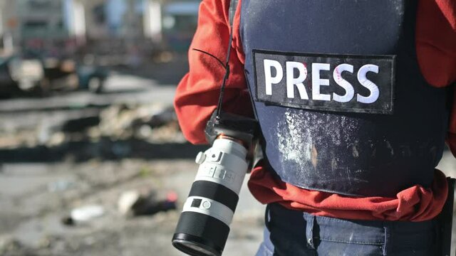One man, war journalist with digital camera at the place of action, in war zone.