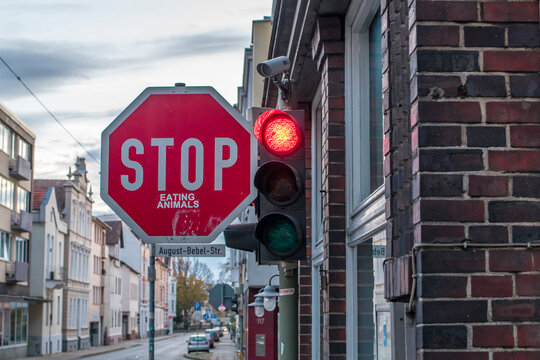 Stop Eating Animals - Ein Stop-Schild mit Aufkleber neben einer roten Ampel