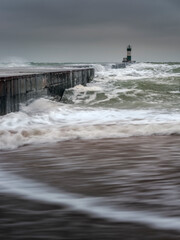 view to pier and landscape in waves and dramatic sky