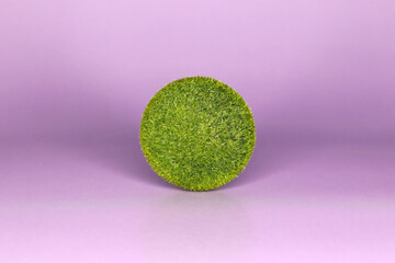 A ball of green grass on a purple background very peri