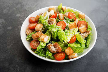 Caesar salad with chicken fillet, cherry tomatoes and croutons, traditional Italian food