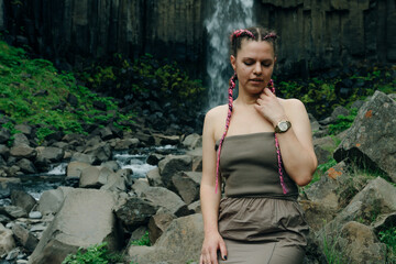 beautiful girl in a dress next to Svartifoss waterfall in the Skaftafell National Park, iceland
