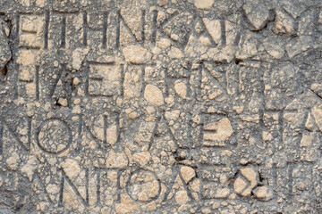 background - half-erased antique inscription on a stone in Phaselis, Turkey