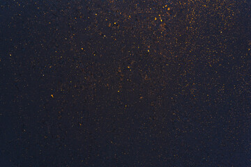 Beautiful, black, winter window glass close-up, covered with shiny, golden ice patterns of frost.