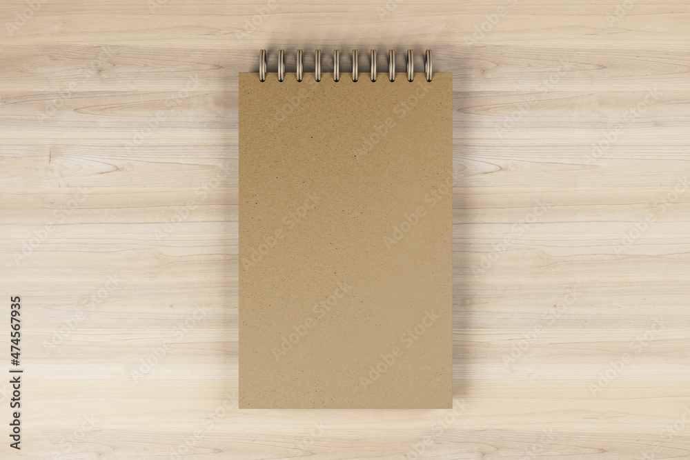 Poster top view and close up of brown spring note pad on wooden desktop background. mock up place for your 