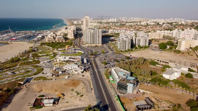 Moving down from the sky to Ashkelon city near Mediterranean sea shore and tall buildings