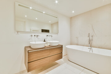 Luxurious bathroom with a beautiful hanging wooden chest of drawers with a sink