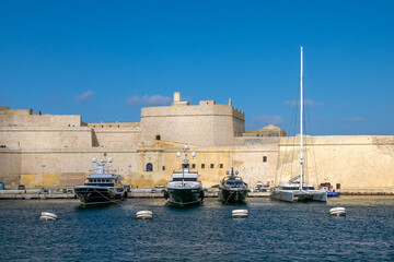 Anchorage of yachts and ships off the coast of the town of Birgu. Water space of Valletta. Fortress from the movie Troy. Malta.