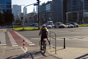 Woman Rides Bicycle in City Center in Modern Street in Autumn Day. Urban Cycle Chic and Ecological Transportation by Bike. 