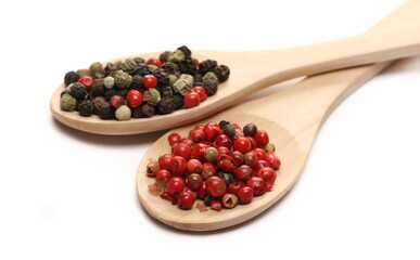 Red and colorful pepper in wooden spoon isolated on white  