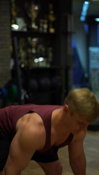 Muscular bodybuilder guy doing exercises in gym.Concept of desire, will and potential. 4k Vertical shot 