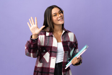 Young student woman isolated on purple background counting five with fingers