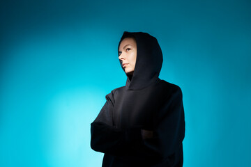 Think, there is an idea. Young woman portrait side view, face partially illuminated, thoughtful look up, dark blue background