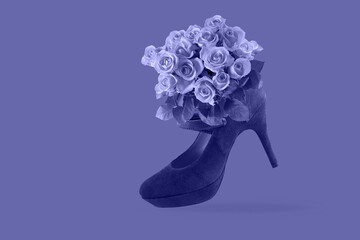 Bouquet of red roses in a high heeled shoe isolated on violet background.