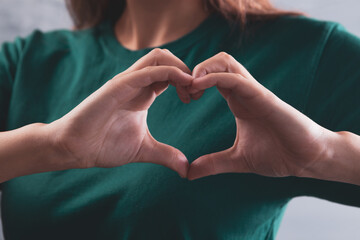 young woman showing a heart with her fingers