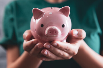 young girl holding a piggy bank