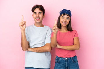 Young couple isolated on pink background showing and lifting a finger in sign of the best