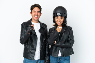 Young mixed race couple with a motorcycle helmet isolated on white background points finger at you with a confident expression