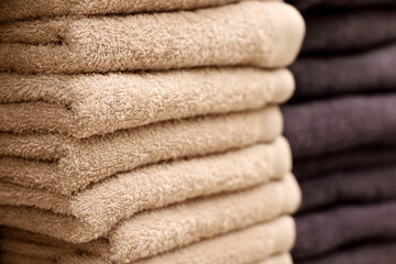 Stack of terry towels, selective focus. Beige and dark bath towel closeup