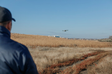 a man looking at a flying drone