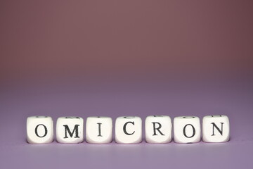 Omicron name of new coronavirus variant written of small cubic letters on violet background	