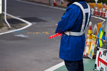 Fototapeta premium 赤く光るLED誘導棒を持った交通誘導員