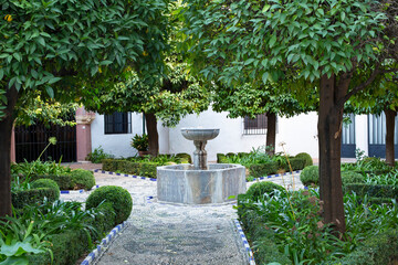 Cordoba, Andalusia, Spain - November 3, 2021: Paths lined with small cobblestones forming a pattern, the fountain of the Museum of Julio Romero de Torres, Cordoba, Spain. Former hospital of charity