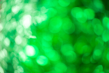 Green blurred background of shimmering bokeh from tinsel. Celebrating New Year and Christmas