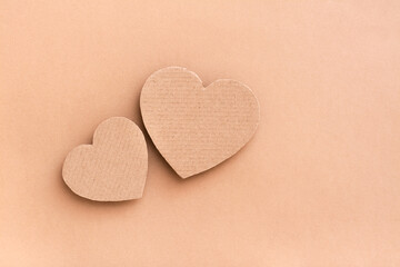 Dating concept. Two cardboard hearts together on a beige background. Top view. Valentine's Day