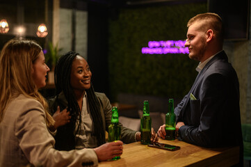 Cheerful colleagues drinking beer in the bar together after work