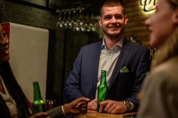 Cheerful colleagues drinking beer in the bar together after work