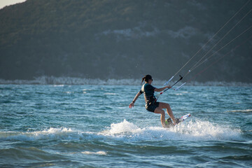 Fototapeta premium Woman kitesurfer athlete splashes on sea waves